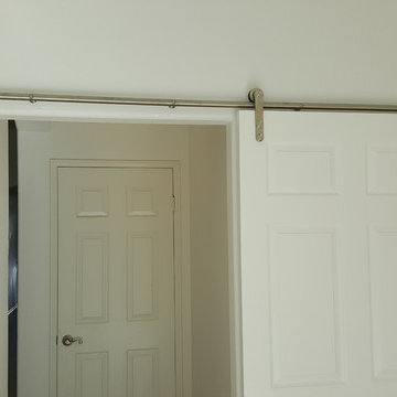 Wide passageway into master bedroom facilitated by barn door enabling full clear