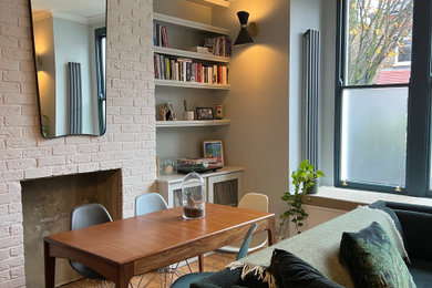 Aménagement d'un salon contemporain avec un mur vert et un sol en bois brun.