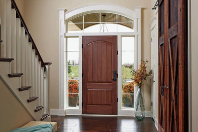 Ejemplo de puerta principal clásica de tamaño medio con paredes beige, suelo de madera oscura, puerta simple y puerta de madera oscura
