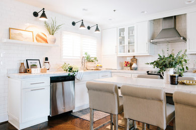 Photo of a small transitional l-shaped open plan kitchen in Other with an undermount sink, shaker cabinets, white cabinets, marble benchtops, white splashback, subway tile splashback, stainless steel appliances, dark hardwood floors, with island, brown floor and white benchtop.