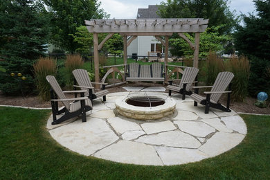 Mid-sized elegant backyard stone patio photo in Other with a fire pit