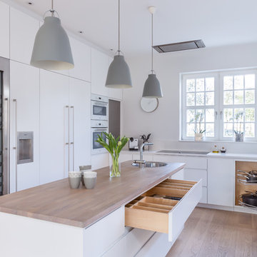 Sleek Scandinavian kitchen in white with separate pantry