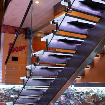 Glass private bar and glass stair treads inside a man cave in Michigan