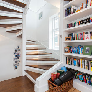 Photo of a small contemporary wood curved staircase in London with open risers.