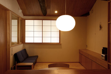 This is an example of an asian living room in Kyoto with beige walls and light hardwood floors.