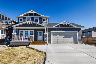 Example of a mid-sized arts and crafts gray two-story vinyl gable roof design in Toronto