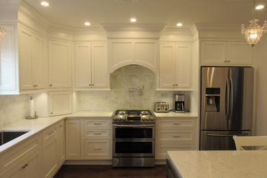 Inspiration for a mid-sized timeless l-shaped dark wood floor and brown floor enclosed kitchen remodel in New York with an undermount sink, beaded inset cabinets, white cabinets, quartz countertops, multicolored backsplash, marble backsplash and stainless steel appliances