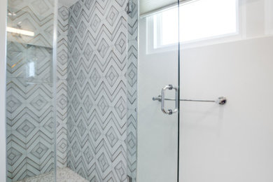 Mid-sized mid-century modern master white tile marble floor, multicolored floor and single-sink corner shower photo in Los Angeles with flat-panel cabinets, light wood cabinets, a one-piece toilet, white walls, a pedestal sink, marble countertops, white countertops and a floating vanity