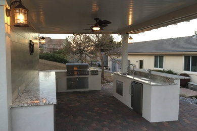 Inspiration for a mid-sized timeless side yard brick patio kitchen remodel in Other with a gazebo