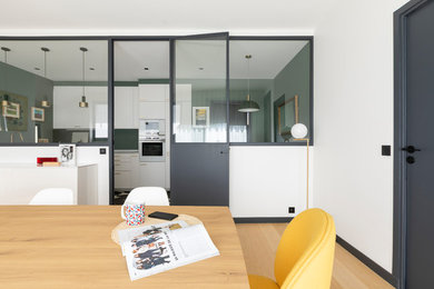 Réalisation d'une salle à manger ouverte sur le salon design de taille moyenne avec un mur blanc, parquet clair et une cheminée standard.