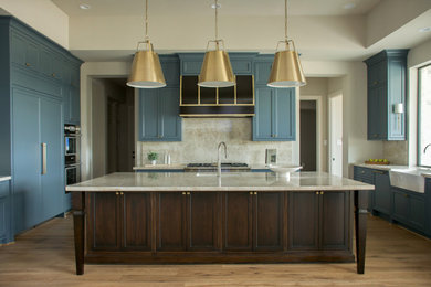 Kitchen - large transitional u-shaped medium tone wood floor and brown floor kitchen idea in Houston with a farmhouse sink, shaker cabinets, blue cabinets, quartzite countertops, beige backsplash, stone slab backsplash, stainless steel appliances, an island and beige countertops