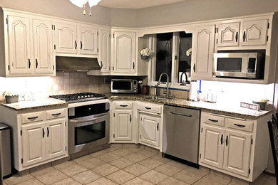 Mid-sized cottage eat-in kitchen photo in Philadelphia with an undermount sink, white cabinets, granite countertops, beige backsplash, stone tile backsplash, stainless steel appliances and no island