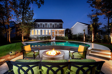 Example of a mid-sized transitional backyard stone and custom-shaped infinity pool design in Charleston