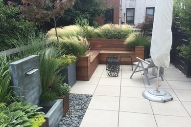 Photo of a mid-sized contemporary courtyard patio in New York with a container garden, tile and no cover.