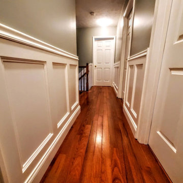 Hallway with custom wainscoting and hardwood flooring