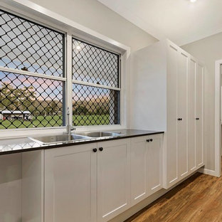 Traditional kitchen pantry appliance - Example of a classic single-wall vinyl floor and brown floor kitchen pantry design in Townsville with a double-bowl sink, shaker cabinets, white cabinets, no island and quartz countertops