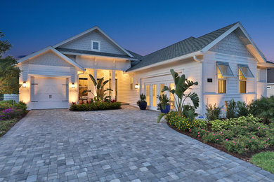This is an example of a large beach style one-storey white house exterior in Jacksonville with concrete fiberboard siding, a hip roof and a shingle roof.