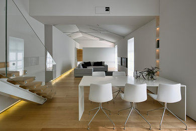 Modern dining room in Milan with white walls and light hardwood floors.