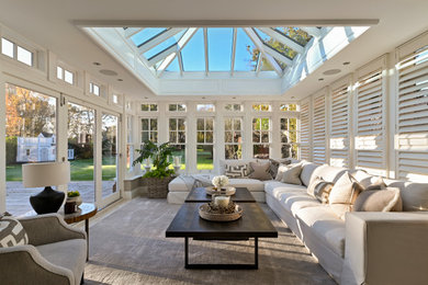 Пример оригинального дизайна: большая терраса в стиле неоклассика (современная классика) с ковровым покрытием, стеклянным потолком и серым полом без камина