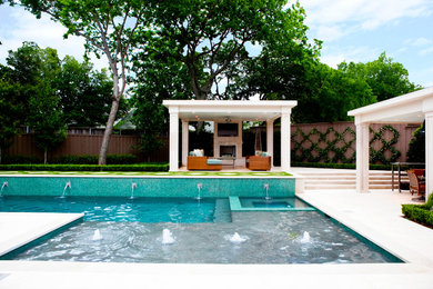 Photo of a mid-sized transitional backyard l-shaped pool in Dallas with a water feature and natural stone pavers.