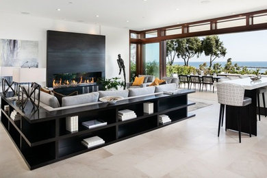 This is an example of an expansive contemporary formal open concept living room in Orange County with white walls, limestone floors, a ribbon fireplace, a tile fireplace surround, no tv and beige floor.