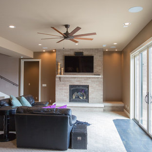 Ejemplo de sótano con puerta clásico, grande, con paredes marrones, moqueta, chimenea tradicional, marco de chimenea de ladrillo y suelo beige