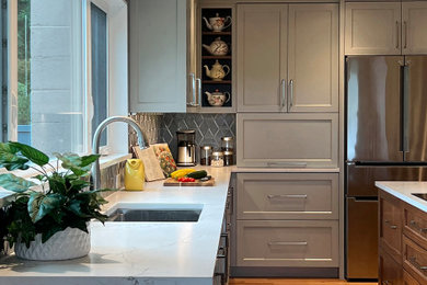 Eat-in kitchen - large transitional u-shaped medium tone wood floor and brown floor eat-in kitchen idea in Seattle with an undermount sink, shaker cabinets, blue cabinets, quartz countertops, blue backsplash, ceramic backsplash, stainless steel appliances, an island and white countertops