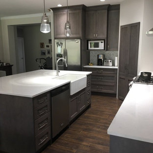 Mid-sized transitional kitchen pantry ideas - Mid-sized transitional l-shaped dark wood floor and brown floor kitchen pantry photo in Vancouver with a farmhouse sink, shaker cabinets, gray cabinets, marble countertops, gray backsplash, matchstick tile backsplash, stainless steel appliances and an island