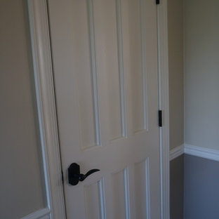 フィラデルフィアの中サイズのカントリー風おしゃれな家事室 (アンダーカウンターシンク、レイズドパネル扉のキャビネット、ヴィンテージ仕上げキャビネット、御影石カウンター、グレーの壁、磁器タイルの床、左右配置の洗濯機・乾燥機) の写真