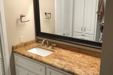 Example of a mid-sized classic 3/4 beige tile and ceramic tile ceramic tile and beige floor alcove shower design in Other with raised-panel cabinets, white cabinets, beige walls, an undermount sink, granite countertops and a hinged shower door
