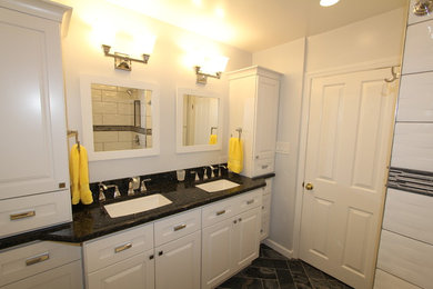 Example of a small transitional 3/4 white tile and porcelain tile porcelain tile and black floor bathroom design in DC Metro with raised-panel cabinets, white cabinets, a two-piece toilet, white walls, an undermount sink and granite countertops