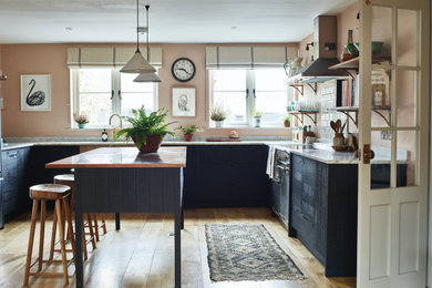 Rustic kitchen/diner in Hertfordshire with a double-bowl sink, black cabinets, copper worktops, marble splashback, integrated appliances, light hardwood flooring and an island.