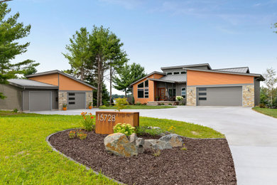 Example of a large trendy multicolored two-story mixed siding house exterior design in Other with a shed roof and a metal roof