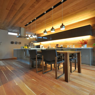 Retro Wohnküche ohne Kamin mit weißer Wandfarbe, braunem Holzboden und orangem Boden in Sonstige