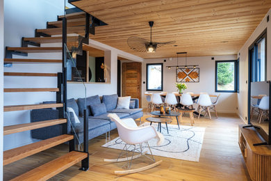 Cette image montre un salon blanc et bois chalet de taille moyenne et ouvert avec un mur blanc, un sol en carrelage de céramique, un téléviseur indépendant, un sol marron, un escalier et un plafond en bois.