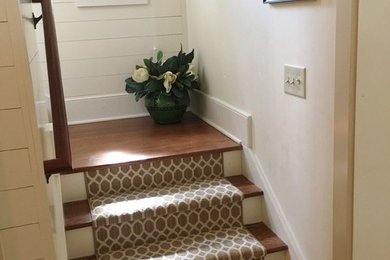 This is an example of a mid-sized traditional wood u-shaped staircase in Charleston with painted wood risers.