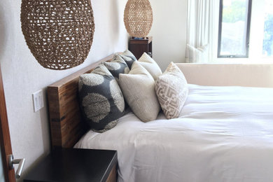 Example of a mid-sized beach style master carpeted and white floor bedroom design in Austin with white walls and no fireplace