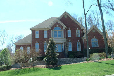 Example of a mid-sized brown two-story brick gable roof design in Nashville