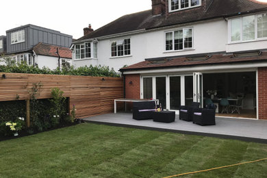 Inspiration for a medium sized contemporary back partial sun garden for summer in London with a wood fence.