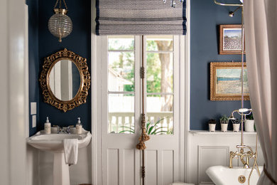 Foto de cuarto de baño único tradicional con bañera con patas, paredes azules, suelo de madera oscura, lavabo con pedestal, suelo marrón y ducha con cortina