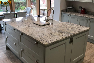 Photo of a large country kitchen in Other with a farmhouse sink, shaker cabinets, blue cabinets, granite benchtops, grey splashback, granite splashback, porcelain floors, with island and grey benchtop.