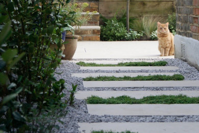 Design ideas for a small rustic back partial sun garden in London with a flowerbed and natural stone paving.