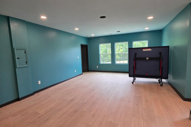 Inspiration for a large laminate floor basement game room remodel in Charlotte