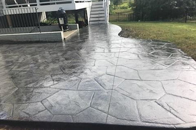 Patio - mid-sized backyard stamped concrete patio idea in Other