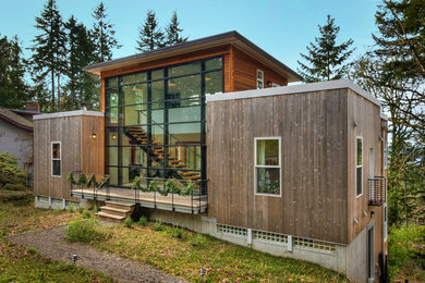 Photo of a contemporary two-storey exterior in Other with wood siding.