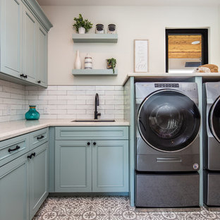Mittelgroße Moderne Waschküche in L-Form mit Unterbauwaschbecken, Schrankfronten mit vertiefter Füllung, blauen Schränken, beiger Wandfarbe, Waschmaschine und Trockner nebeneinander, beiger Arbeitsplatte, Quarzwerkstein-Arbeitsplatte, Keramikboden und buntem Boden in San Diego