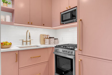 Enclosed kitchen - small u-shaped porcelain tile and pink floor enclosed kitchen idea in New York with an undermount sink, flat-panel cabinets, pink cabinets, quartz countertops, white backsplash, subway tile backsplash, stainless steel appliances and multicolored countertops