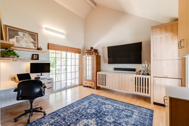 Large transitional built-in desk medium tone wood floor and vaulted ceiling home office photo in Sacramento with white walls and no fireplace