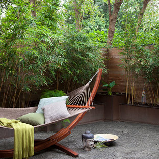 Exemple d'un jardin à la française asiatique de taille moyenne avec du gravier et un mur de soutènement.