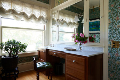 Example of a large classic double-sink, medium tone wood floor, brown floor and wallpaper bathroom design in Portland with recessed-panel cabinets, dark wood cabinets, green walls, marble countertops, white countertops and a built-in vanity